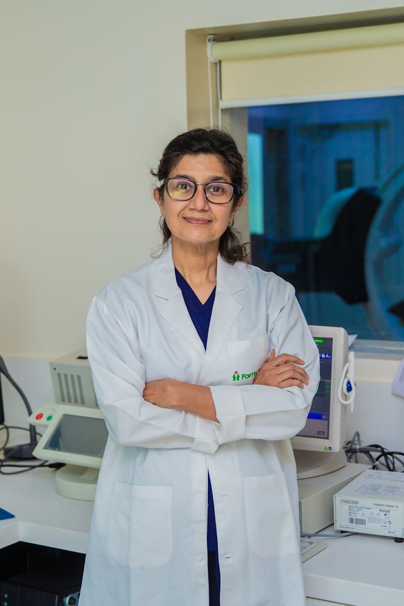Home Confident female doctor with arms crossed in a modern medical laboratory setting in Delhi, India.