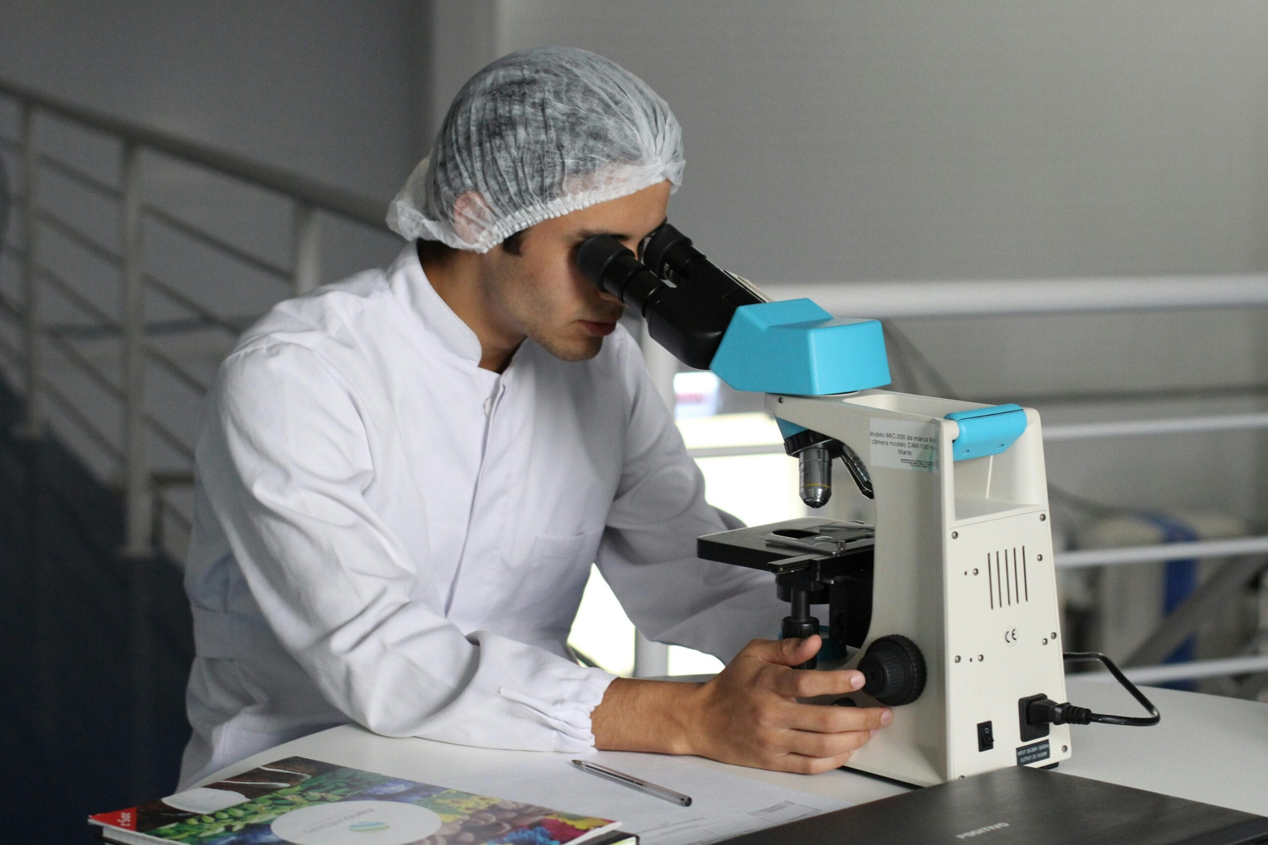Home Scientist in a lab coat using a microscope to conduct research, focusing on healthcare improvements.